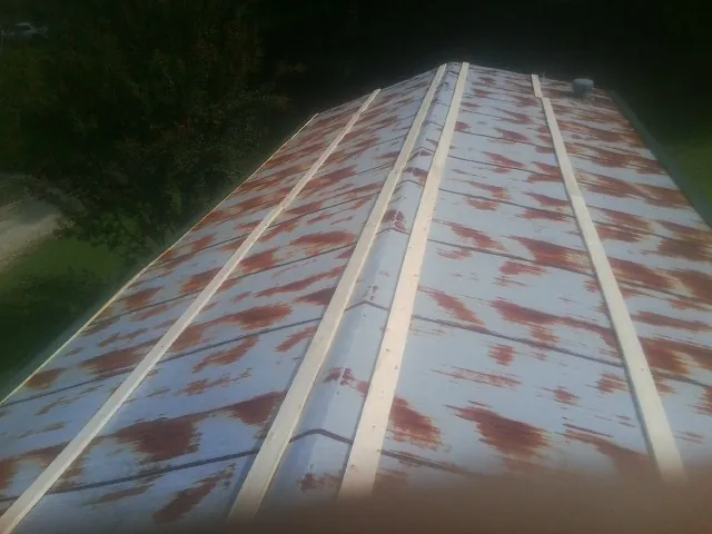 Rusted metal roof panels with new wood purlins before replacement — Storm Damage Roof Repair in Mccloud by Roofing Brothers