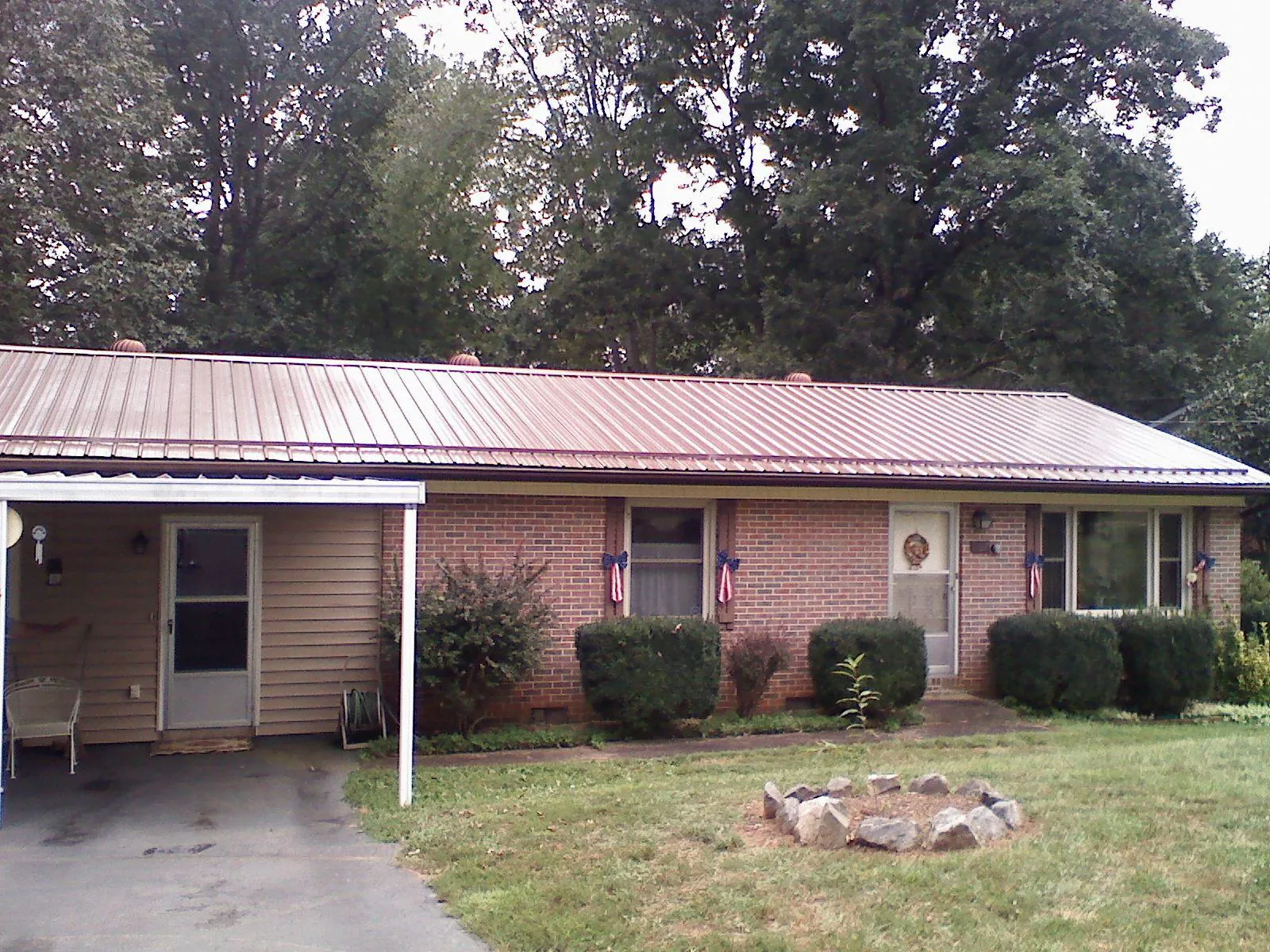 Bronze metal roof and carport on a brick ranch home — Roof Repair work by our crew in Mccloud
