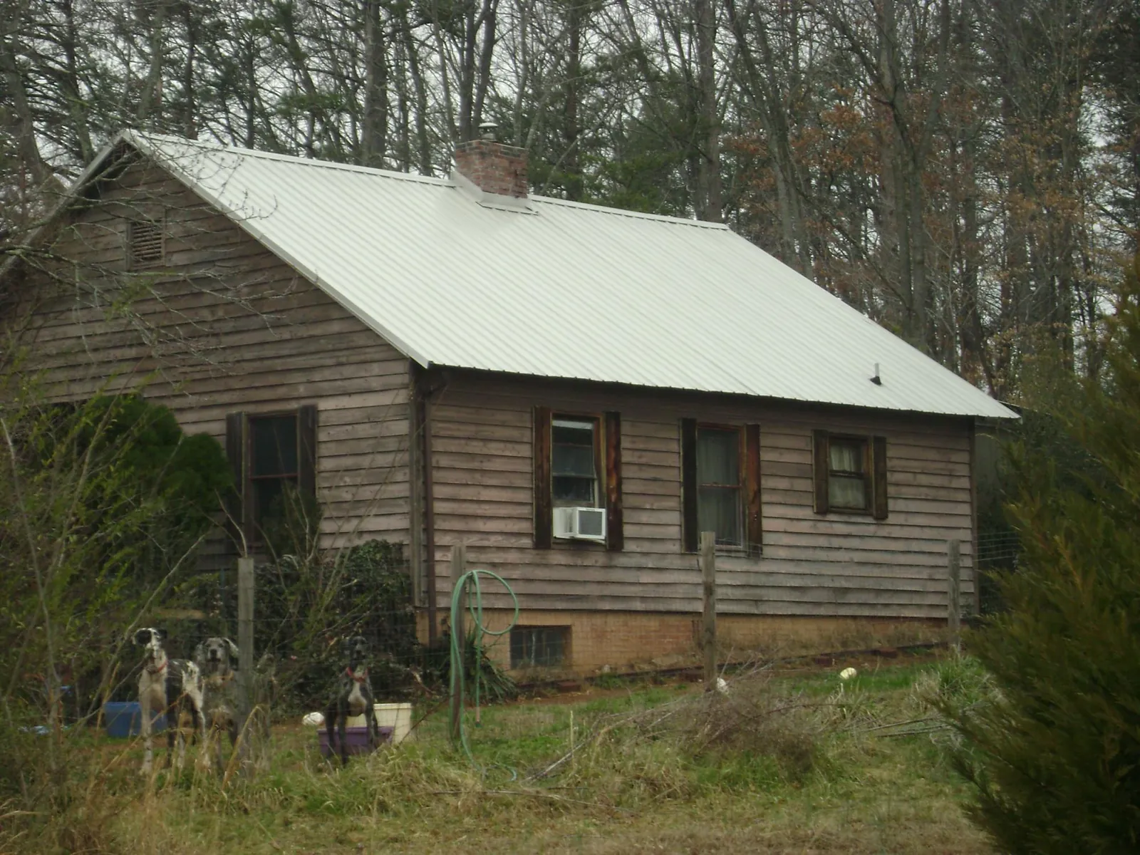 White metal roof on an old wood sided farmhouse, from a Metal Roof Installation job in Mccloud